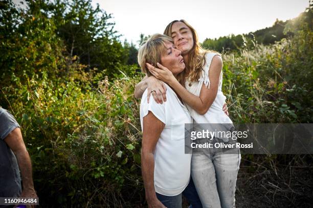 happy mother and adult daughter hugging in the countryside - daughter stock-fotos und bilder