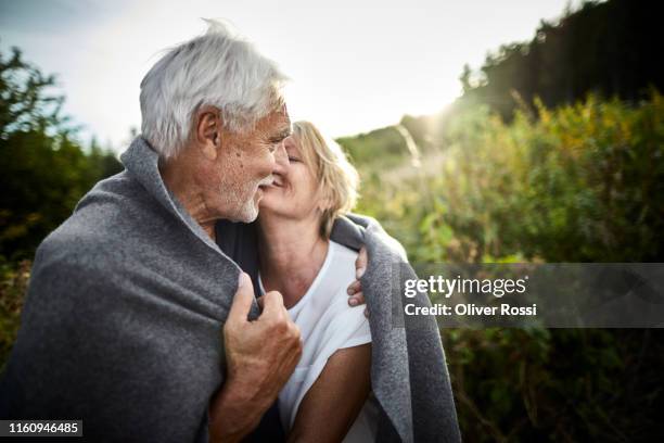 mature couple wrapped in a blanket cuddling in the countryside - non moving activity bildbanksfoton och bilder