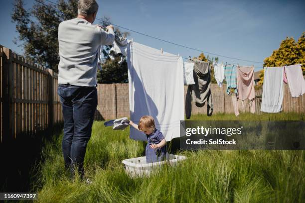 aider papa avec les travaux ménagers - renversement des rôles photos et images de collection