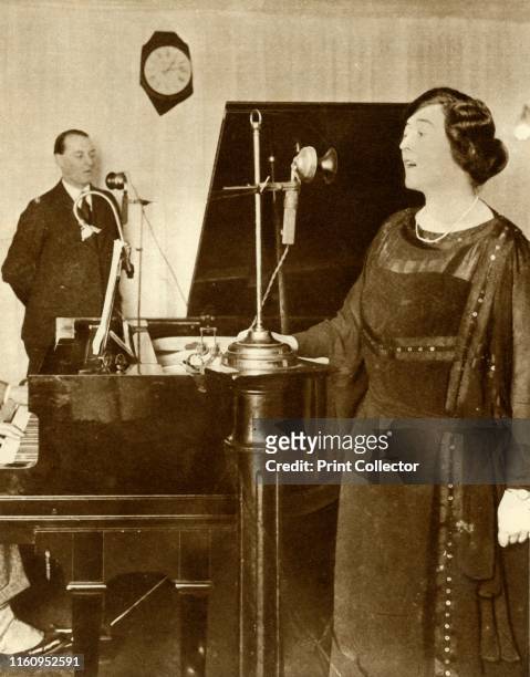 Performers singing a duet in one of the studios of 2LO, Savoy Hill, London, 1923. 2LO was the second radio station to broadcast regularly in the...