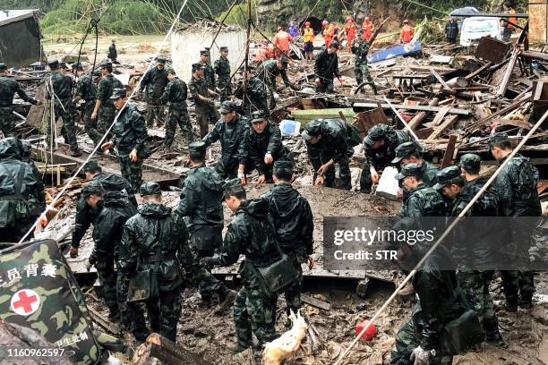 Rescuers and paramilitary police officers search in the rubble of damaged buildings after torrential rain caused by Typhoon Lekima, at Yongjia, in...