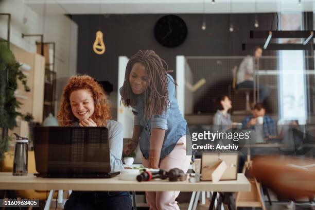 senior art director mentoring new intern in modern office - people showing respect stock pictures, royalty-free photos & images
