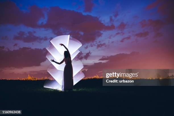 woman in nature in front of light painting - abstract geometric silhouette woman stock pictures, royalty-free photos & images