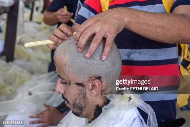 Muslim pilgrims have their heads shaven by barbers upon leaving Muzdalifah after throwing pebbles as part on the symbolic al-Aqabah at the Jamarat...