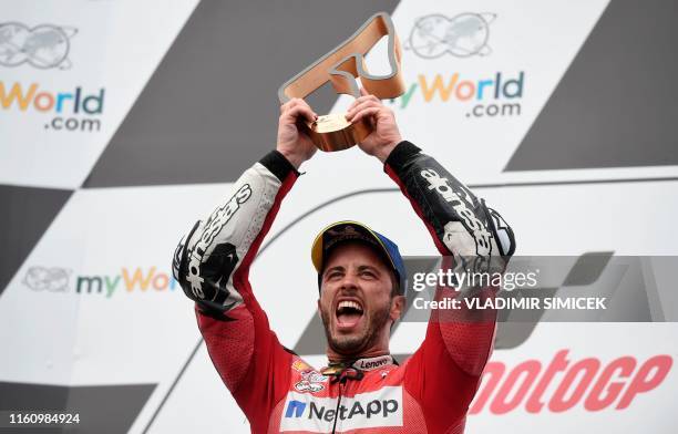 Mission Winnow Ducati's Italian rider Andrea Dovizioso celebrates on the podium with his trophy after winning the Austrian Moto GP Grand Prix in...