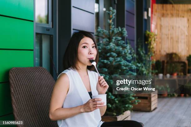 young woman enjoying food at home - mulher colher sorvete imagens e fotografias de stock