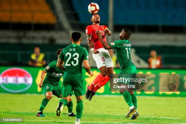 Guangzhou Evergrande's Paulinho heads the ball during the Chinese Super League football match between Beijing Guoan and Guangzhou Evergrande in...