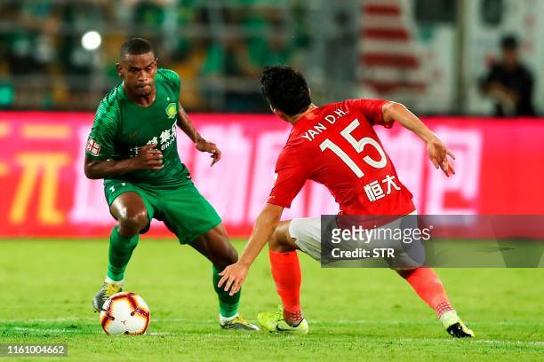 Beijing Guoan's Fernando Lucas Martins fights for the ball with Guangzhou Evergrande's Yan Dinghao during their Chinese Super League football match...