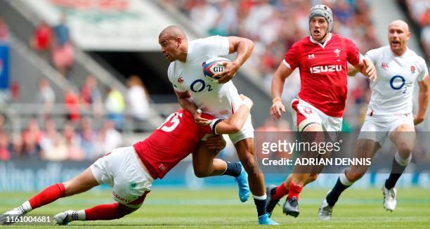 England's centre Jonathan Joseph gets tackled by Wales' full-back Liam Williams during the international Test rugby union match between England and...