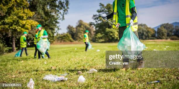 volunteers picking up trash in a park - planet observer stock pictures, royalty-free photos & images