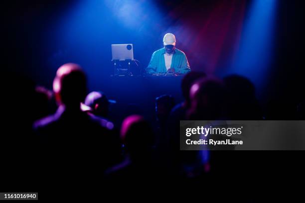 dj performing music set with light display - black dj stock pictures, royalty-free photos & images