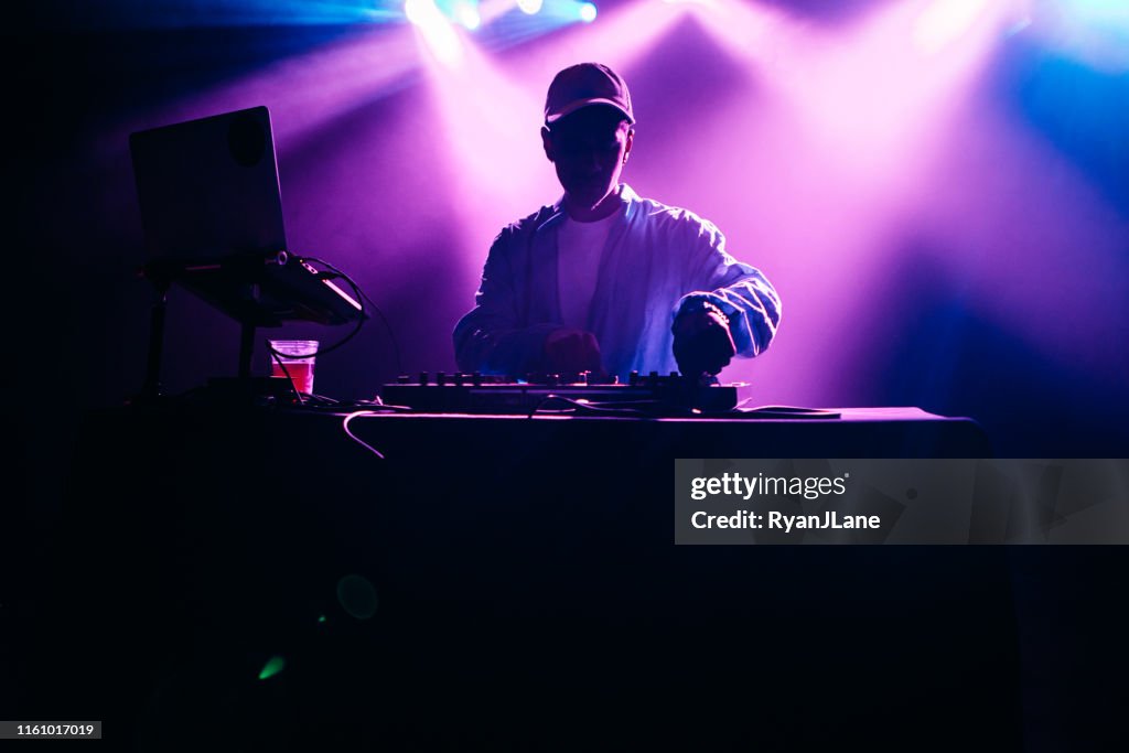 DJ interpretando un conjunto de música con pantalla de luz