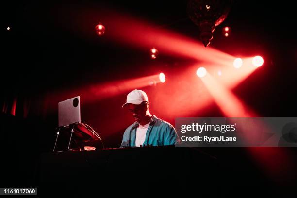 dj performing music set with light display - dj club stock pictures, royalty-free photos & images