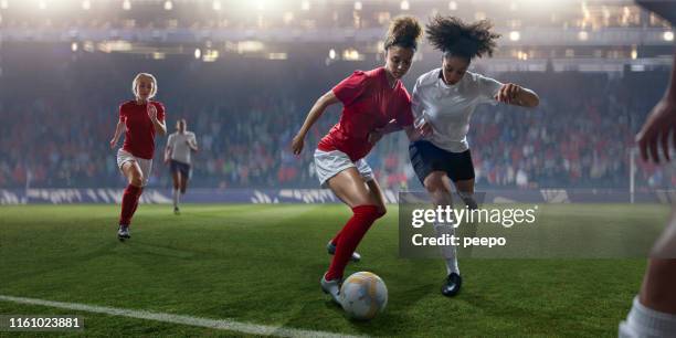 profesional mujeres jugador de fútbol dribbling ball pasado rival durante el partido - fémina fotografías e imágenes de stock