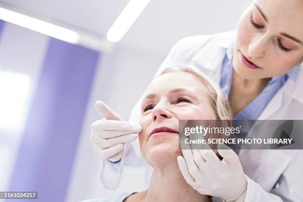 doctor examining patient - dermatologia fotografías e imágenes de stock