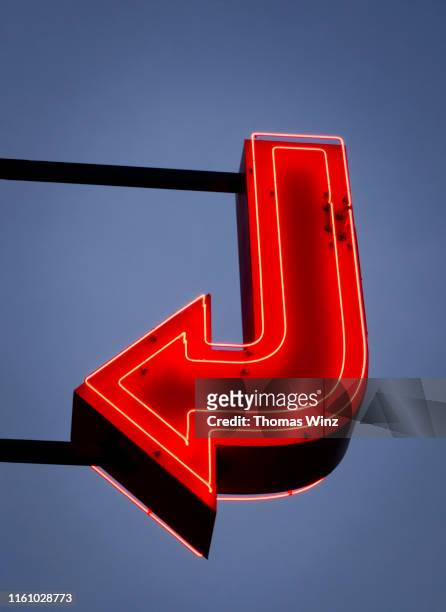 red neon arrow - neon sign arrow stockfoto's en -beelden