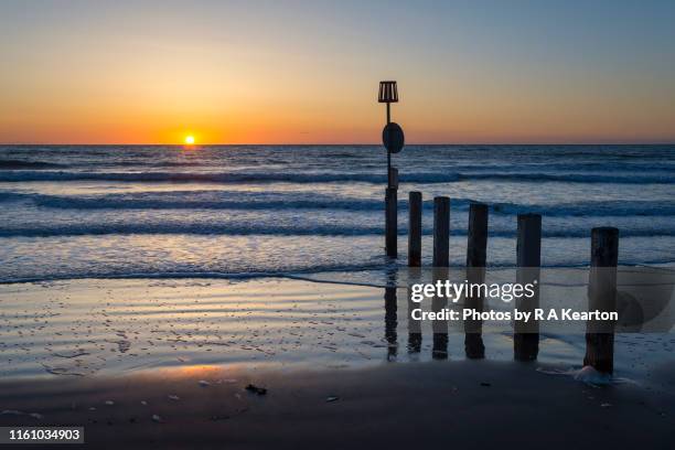 beautiful sunset on the coast of west wales - stakes in the sand stock pictures, royalty-free photos & images