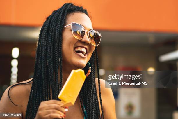 mujer afro comiendo geladinho o chupchup - sorbet fotografías e imágenes de stock