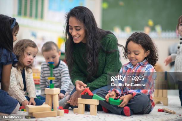 teacher playing with students - montessori education stock pictures, royalty-free photos & images