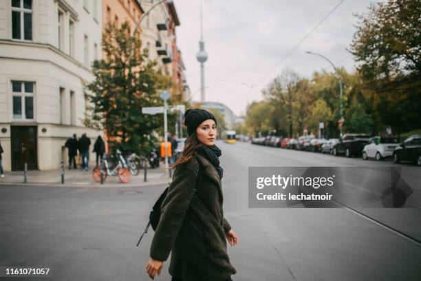 young woman walking in berlin mitte - prenzlauer berg imagens e fotografias de stock