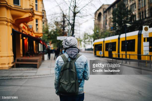 junger mann zu fuß durch die straßen von berlin - berlin prenzlauer berg stock-fotos und bilder