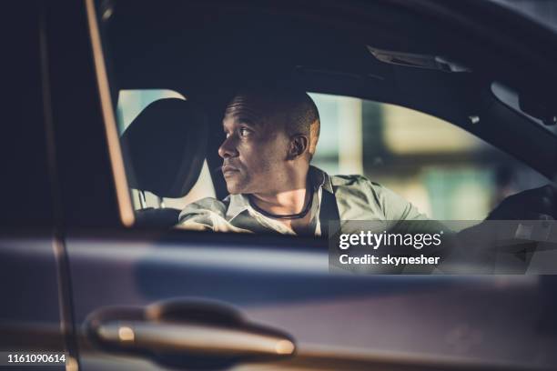 mittelerwachsene afroamerikanische geschäftsmann parken sein auto in umgekehrter richtung. - reverse stock-fotos und bilder