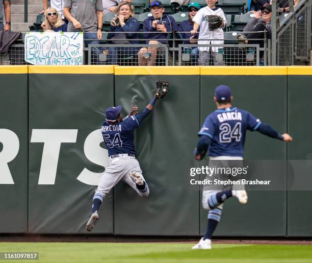 Centerfielder Guillermo Heredia of the Tampa Bay Rays hits the wall as he makes a catch on a ball hit by Austin Nola of the Seattle Mariners during...