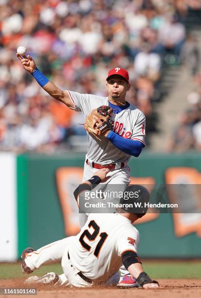 Cesar Hernandez of the Philadelphia Phillies completes the double-play throwing over the top of Stephen Vogt of the San Francisco Giants in the...