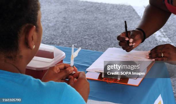 Karen McKenzie of the Orange County, Florida Health Department prepares to administer the hepatitis A vaccine to an attendee at a hepatitis A...