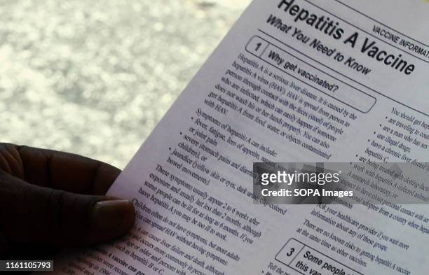 Man reads an information sheet at a hepatitis A vaccination event sponsored by the Orange County, Florida Health Department in response to the...