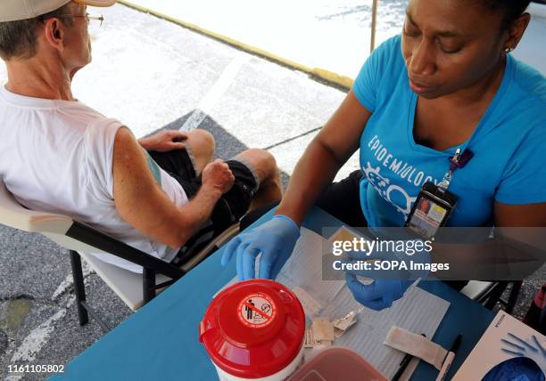 Karen McKenzie of the Orange County, Florida Health Department prepares to administer the hepatitis A vaccine to Nelson Fitzpatrick at a hepatitis A...