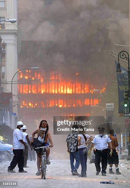 People walk in the street in the area where the World Trade Center buildings collapsed September 11, 2001 after two airplanes slammed into the twin...