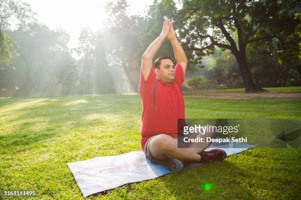 mature man workout in park - sun salutation stock pictures, royalty-free photos & images