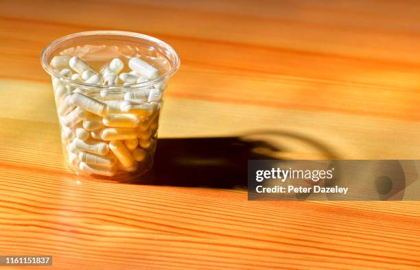 excess pills in a plastic cup/pot, potential suicide - codeine stock pictures, royalty-free photos & images