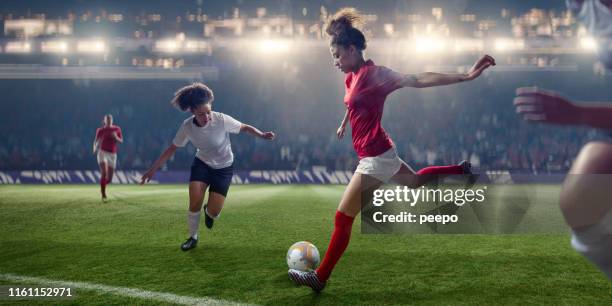 profi-fußballerin beim kicken während des spiels - sportbegegnung stock-fotos und bilder