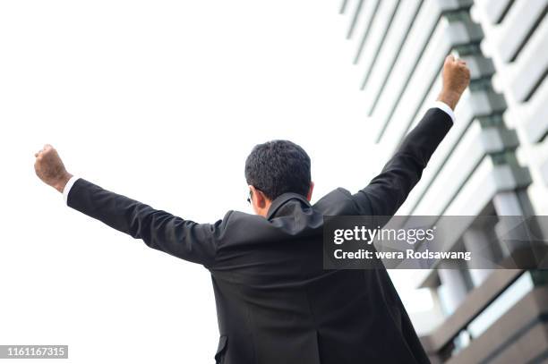 businessman standing back and raising hand up - growth mindset stock pictures, royalty-free photos & images