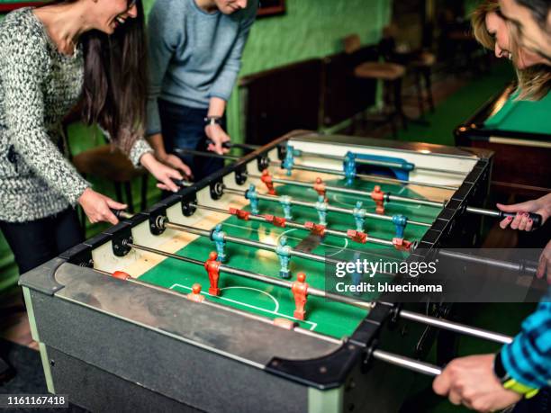 freinds playing foosball - table football stock pictures, royalty-free photos & images