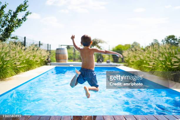 hello summer holidays - boy jumping in swimming pool - swimming pool stock pictures, royalty-free photos & images