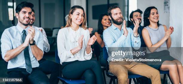 audience applauding speaker at business conference - applauding staff stock pictures, royalty-free photos & images