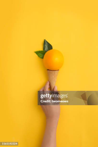 orange flavour ice cream concept image. - a cone stock-fotos und bilder