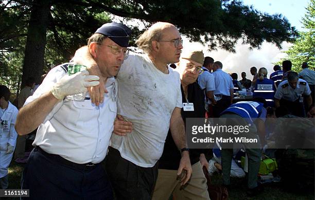 An injured man gets some help after being taken out of the Pentagon after a plane crashed into the building September 11, 2001 in Arlington, VA.