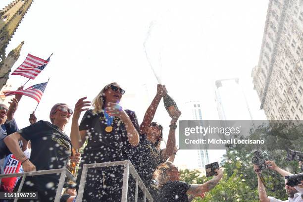 Megan Rapinoe, Allie Long and Alex Morgan celebrate while riding on a float during The U.S. Women's National Soccer Team Victory Parade and City Hall...