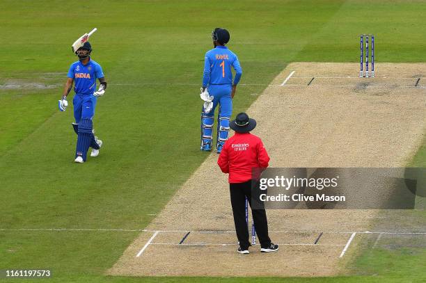 Virat Kohli of India throws his bat in the air after being dismissed off the bowling of Trent Boult of New Zealand during the Semi-Final match of the...