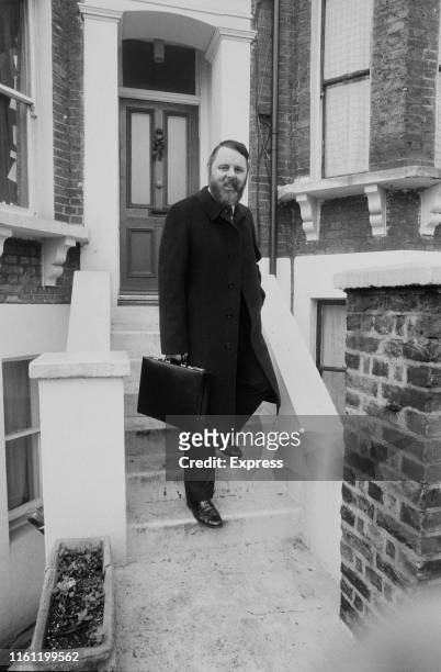 English humanitarian and author Terry Waite holding a briefcase on the steps of a Victorian house, UK, 31st December 1984.