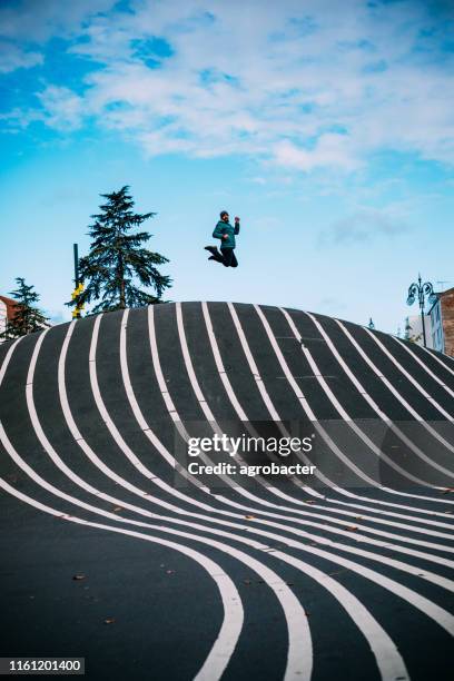 man jumping at superkilen park in copenhagen - copenhagen park stock pictures, royalty-free photos & images