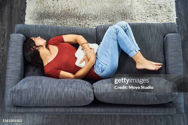 vielleicht wird diese heißwasserflasche den schmerz lindern - wärmflasche stock-fotos und bilder