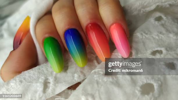 close-up of woman fingers with nail art manicure with neon rainbowcolour - ombré imagens e fotografias de stock