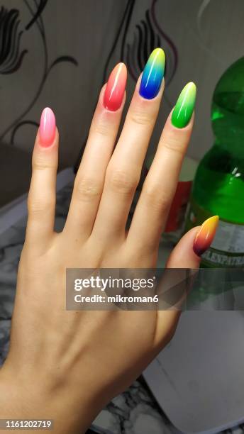 close-up of woman fingers with nail art manicure with neon rainbowcolour - nagelkunst stockfoto's en -beelden