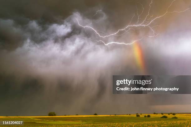 lightning lights up falling hail with a rainbow at sunset, taken south of the town of superior, nebraska - landscap with rainbow fotografías e imágenes de stock