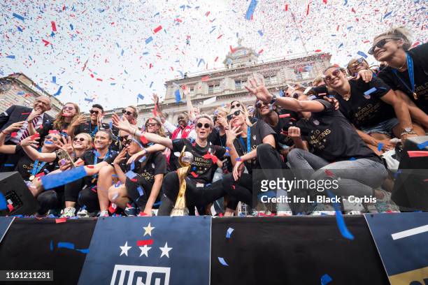 Members of the USA Women's National Soccer Team stand in front of the 2019 FIFA World Cup Trophy and get showered by confetti after the City Hall...